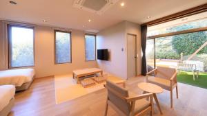 a hotel room with a bed and a table and chairs at ゆるり熱海withDOGS in Atami