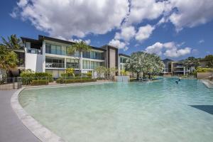a large swimming pool in front of a building at Blue on Blue Apartment 1015 in Nelly Bay