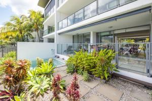 an apartment building with a swimming pool and plants at Blue on Blue Apartment 1015 in Nelly Bay