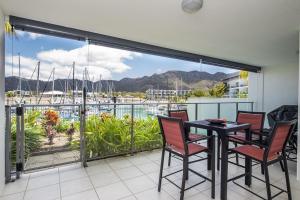 a balcony with a table and chairs and a view of a marina at Blue on Blue Apartment 1015 in Nelly Bay +17 photos
