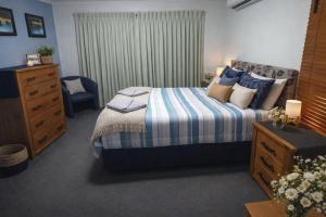 a bedroom with a bed and a dresser and a window at Banksia Hideaway Kgari in Fraser Island +10 photos