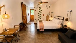 a bedroom with a bed and a couch at Finca Ki' - Eco Farm Stay Bed & Breakfast - El Yunque Region in Naguabo