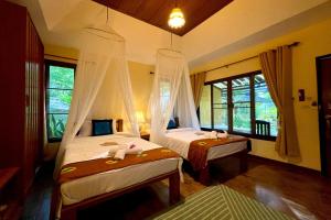 a bedroom with two beds and a window at Villa Khao Phaengma in Wang Nam Khieo +205 photos