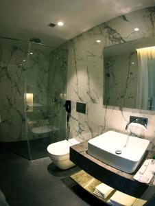 a bathroom with a sink and a toilet and a shower at Connaught Royale in New Delhi +16 photos