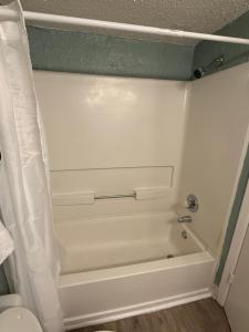 a white bath tub in a bathroom with a toilet at Ocean 12 Beach Hotel in Myrtle Beach