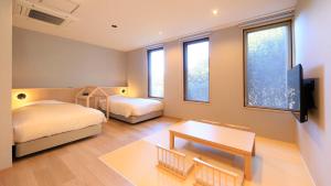 a bedroom with two beds and a flat screen tv at ゆるり熱海withDOGS in Atami +55 photos