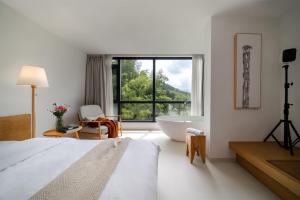 a bedroom with a bed and a tub and a window at Congxi Creek Resort in Conghua +159 photos