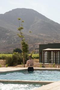 a man is standing in a swimming pool at Nangi Hotel Boutique in Valle de Guadalupe