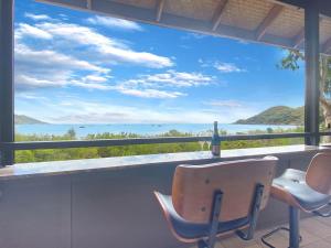 a view of the ocean from a balcony with chairs at Absolute Beachfront and Pool House in Horseshoe Bay +39 photos