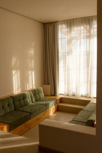a living room with a couch and a window at Nangi Hotel Boutique in Valle de Guadalupe