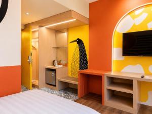 ein Schlafzimmer mit Bett und Fernseher in der Unterkunft Summerday Hotel in Ulin