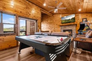 a pool table in a room with a fireplace at Cedar Splash in Sevierville