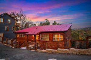 a large wooden house with a red roof at Cedar Splash in Sevierville