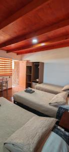 a bedroom with two beds in a room with a table at Lalck Cketi Hotelería y Turismo in San Pedro de Atacama +21 photos