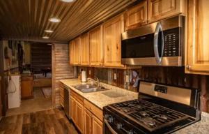 a kitchen with a stove and a microwave at Couples Country Getaway in Pagosa Springs