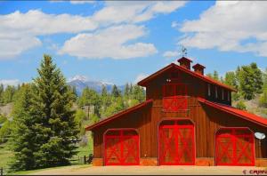 a large red barn with red doors on it at Couples Country Getaway in Pagosa Springs