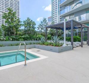 a swimming pool with a pergola next to a building at Viceroy Residences in Miami