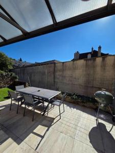 a patio with a table and chairs and a grill at Bleu d'Aubrac Climatisé in Marvejols