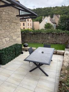 a picnic table and chairs on a patio at Bleu d'Aubrac Climatisé in Marvejols