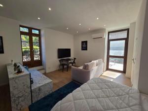 a bedroom with a bed and a living room at Bleu d'Aubrac Climatisé in Marvejols