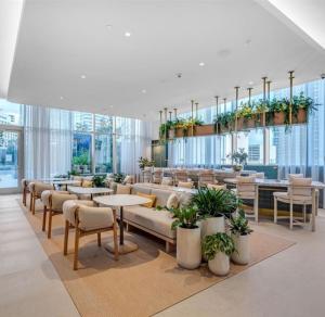 a lobby with tables and chairs and plants at Viceroy Residences in Miami