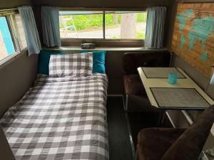 a small room with a bed and a table at Cozy Vintage Camper, the Tealy Wheely in Golden