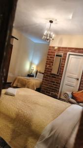 a room with two beds and a brick wall at Posada de Cantuña in Quito