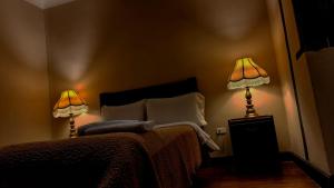 a bedroom with two lamps next to a bed at Posada de Cantuña in Quito