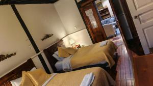 a small room with two beds and a hallway at Posada de Cantuña in Quito