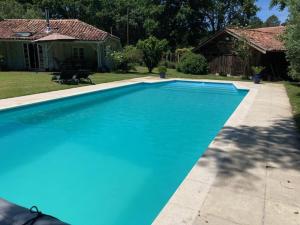 a large blue swimming pool in front of a house at Bois sauvage in Parentis-en-Born