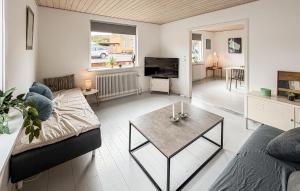 a living room with a couch and a table at Beautiful Home In Allinge With Wifi in Allinge