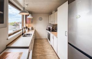 a kitchen with white cabinets and a large window at Beautiful Home In Allinge With Wifi in Allinge