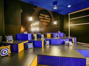 a room with blue tables and a sign with arrows at ibis budget Tambore in Barueri