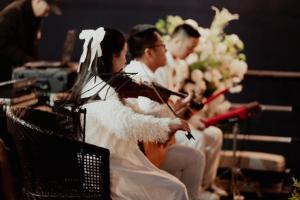 a bride and groom playing their instruments at a wedding at Victorious Cruise Ha Long Bay in Ha Long