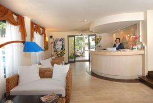 a woman standing at a counter in a hotel lobby at Hotel Europa in San Bartolomeo al Mare