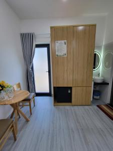a living room with a table and a wooden door at Một Eco-Lodge in Tân Phú