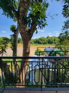 a tree and a fence next to a river at Một Eco-Lodge in Tân Phú +4 photos