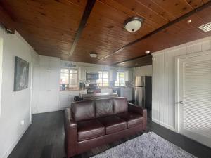 a living room with a leather couch and a kitchen at Hotel-Style Private Suite-Lake View-Gardens in Lake Wales