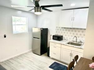 a kitchen with a black refrigerator and a sink at Brisa Marina Suites in New Port Richey