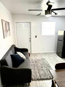 a living room with a black couch and a white door at Brisa Marina Suites in New Port Richey