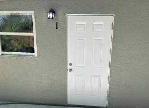 a white door and a window next to a building at Brisa Marina Suites in New Port Richey