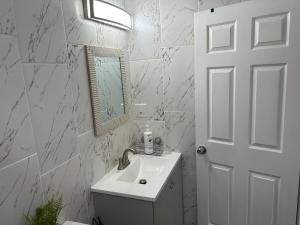 a white bathroom with a sink and a mirror at Brisa Marina Suites in New Port Richey +15 photos