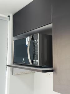 a microwave oven on a shelf in a kitchen at Colseguros in Cali