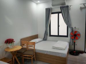 a small bedroom with a bed and a table and a window at Một Eco-Lodge in Tân Phú