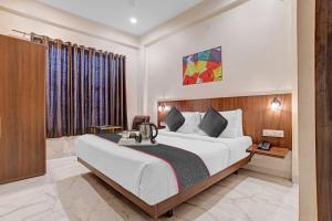 a hotel room with a bed and a desk at Super Townhouse Hotel O Benchmark in Indore