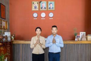 a man and woman standing in front of a counter with clocks at Tanei Angkor Resort and Spa in Siem Reap +130 photos