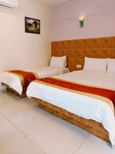 two beds in a hotel room with white sheets at Hotel Seri Nilai in Nilai