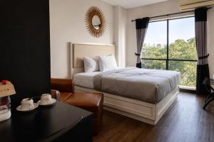 a bedroom with a bed and a large window at Kalya Hotel Bandung Dago in Bandung +49 photos