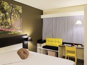 a bedroom with a bed and a desk with a yellow chair at Ibis Styles Porto Alegre Centro - proximo rodoviaria, Araujo Vianna e hospitais in Porto Alegre +27 photos