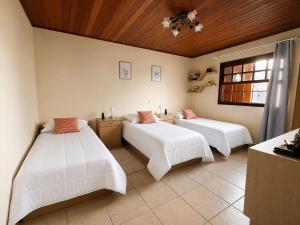 a bedroom with two beds and a ceiling at Flats Morada do Jordão in Campos do Jordão